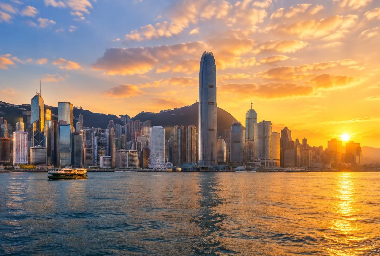 Hong Kong skyline across Victoria Harbour at golden hour